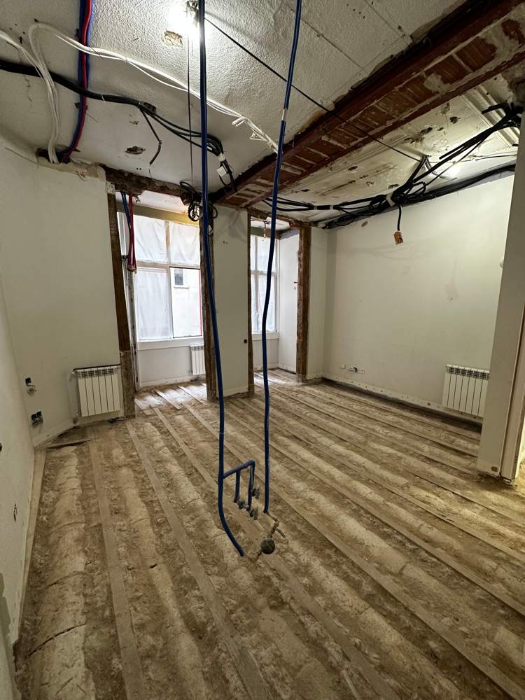 Entramado de madera original a la vista tras la demolición en un piso de Génova