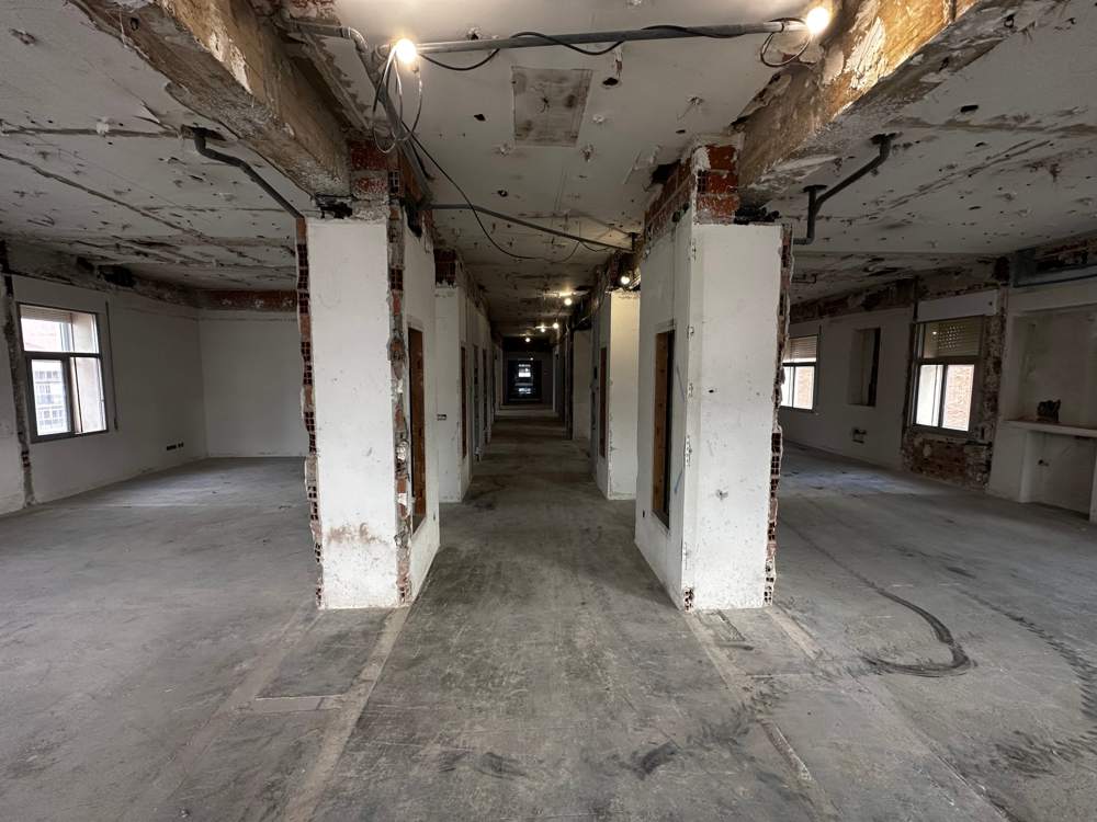 Pasillo central del hospital tras la demolición de tabiques y falsos techos